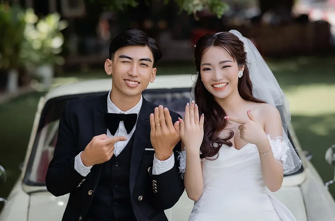 指輪を見せて笑う新郎新婦